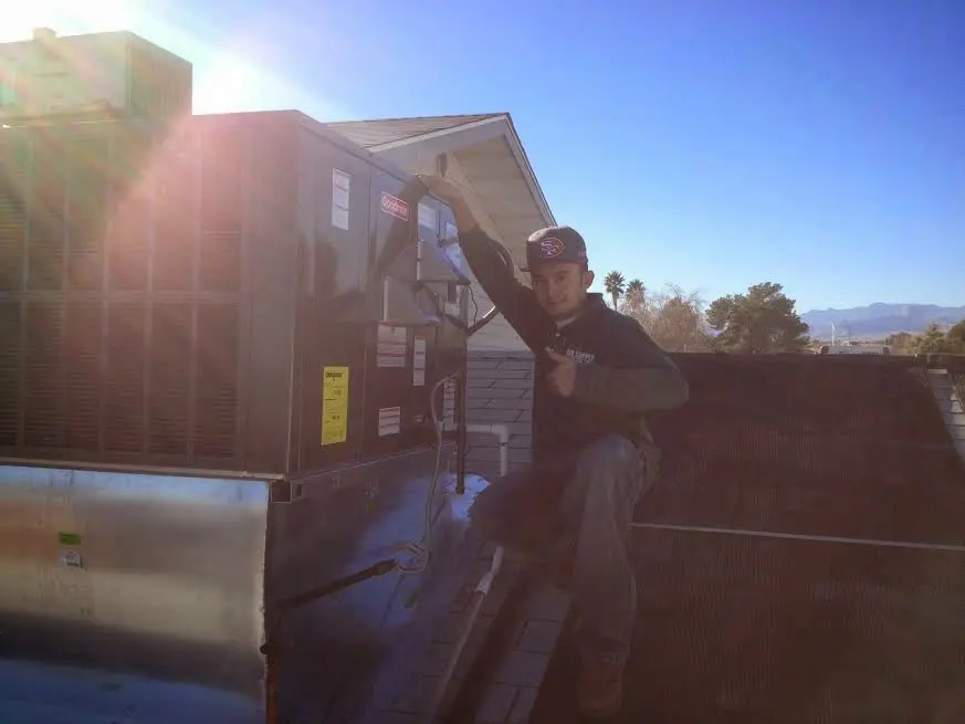 HVAC technician performing AC Tune-Up on a rooftop unit in Banning